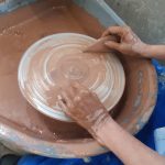 A photograph of someone using a pottery wheel.