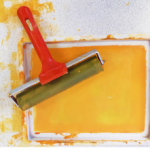 Screen printing roller on tray of yellow paint