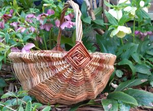 A willow woven basket with flowers in the background