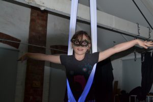 Young gorl with mask on in aerial hammock