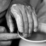 Close up of hand turning a pot on a potter's wheel