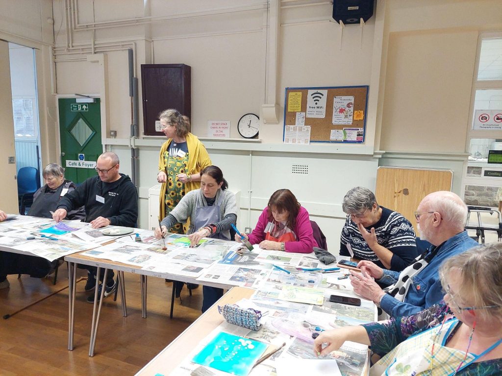 A group of elderly people painting in an art class